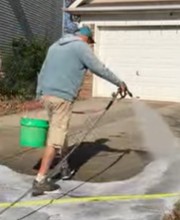 Pre-treatment of driveway before surface cleaning in Charlotte, NC.