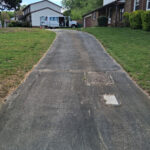 Very dirty driveway heavily stained with black staining before a deep surface cleaning.