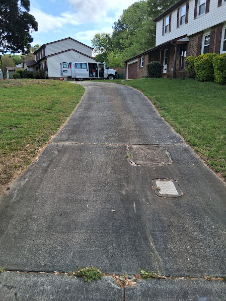 Very dirty driveway heavily stained with black staining before a deep surface cleaning.